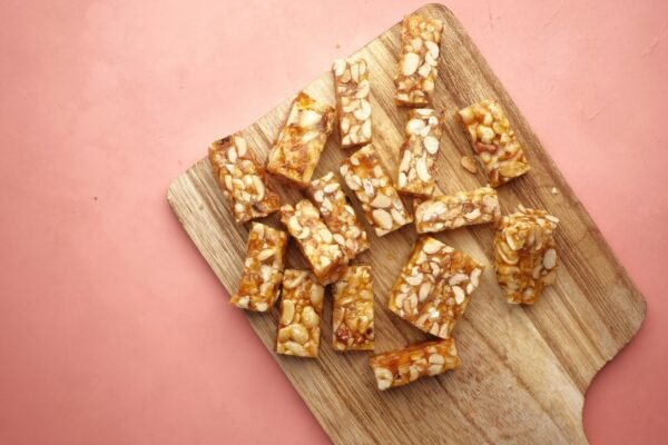 Wooden cutting board displaying tasty homemade nut bars, ready to eat.